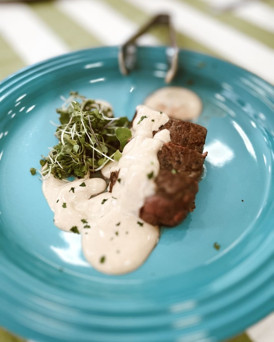 Carne ao creme com brotos servida em prato turquesa