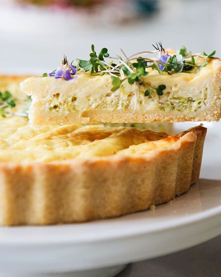 Fatia de quiche de alho-poró sem glúten com flores comestíveis