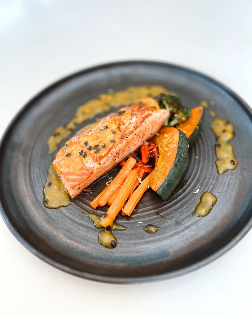 Salmão com legumes salteados em prato rústico
